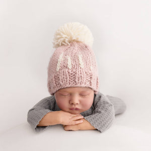 Add a playful pop of color to your little one's wardrobe with our Why Hi There Blush Beanie! Crafted with love and a cute pom on top, this hand knit beanie is the perfect gift for expecting parents or a sweet addition to your own baby's collection. Available in size 0-6 months. James 1:17