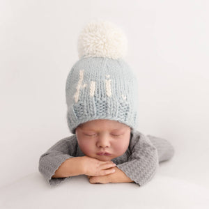 Introducing the Why Hi There Beanie - the cutest addition to any newborn's wardrobe! This blue hand knit baby beanie is complete with an adorable pom on top and is size 0-6 months. Say hello to the perfect gift for expecting parents or a precious addition to your own baby's collection. James 1:17