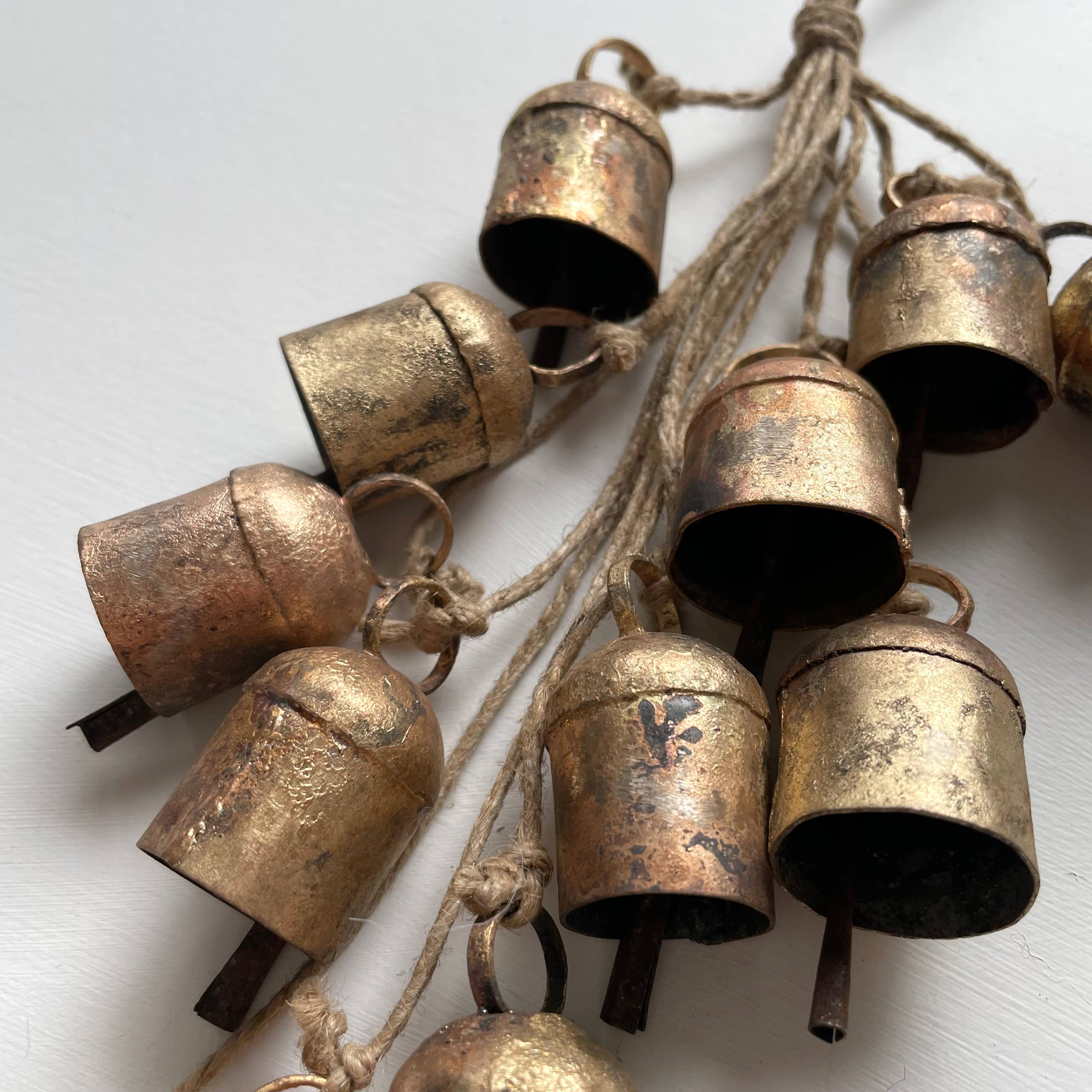 Add some festive charm to your home with these beautiful brass bells! Perfect for holiday decor, they come clustered with jute for a charming touch. Use them to add a touch of whimsy to your wreaths, doorways, mantels, and even countertops. Bring the holiday spirit into every corner of your home with these charming brass bells. As each bell/hanging is handmade, no two are exactly the same and small variations is to be expected in both size and finish.