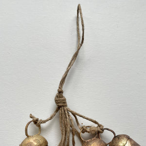 Add some festive charm to your home with these beautiful brass bells! Perfect for holiday decor, they come clustered with jute for a charming touch. Use them to add a touch of whimsy to your wreaths, doorways, mantels, and even countertops. Bring the holiday spirit into every corner of your home with these charming brass bells. As each bell/hanging is handmade, no two are exactly the same and small variations is to be expected in both size and finish.